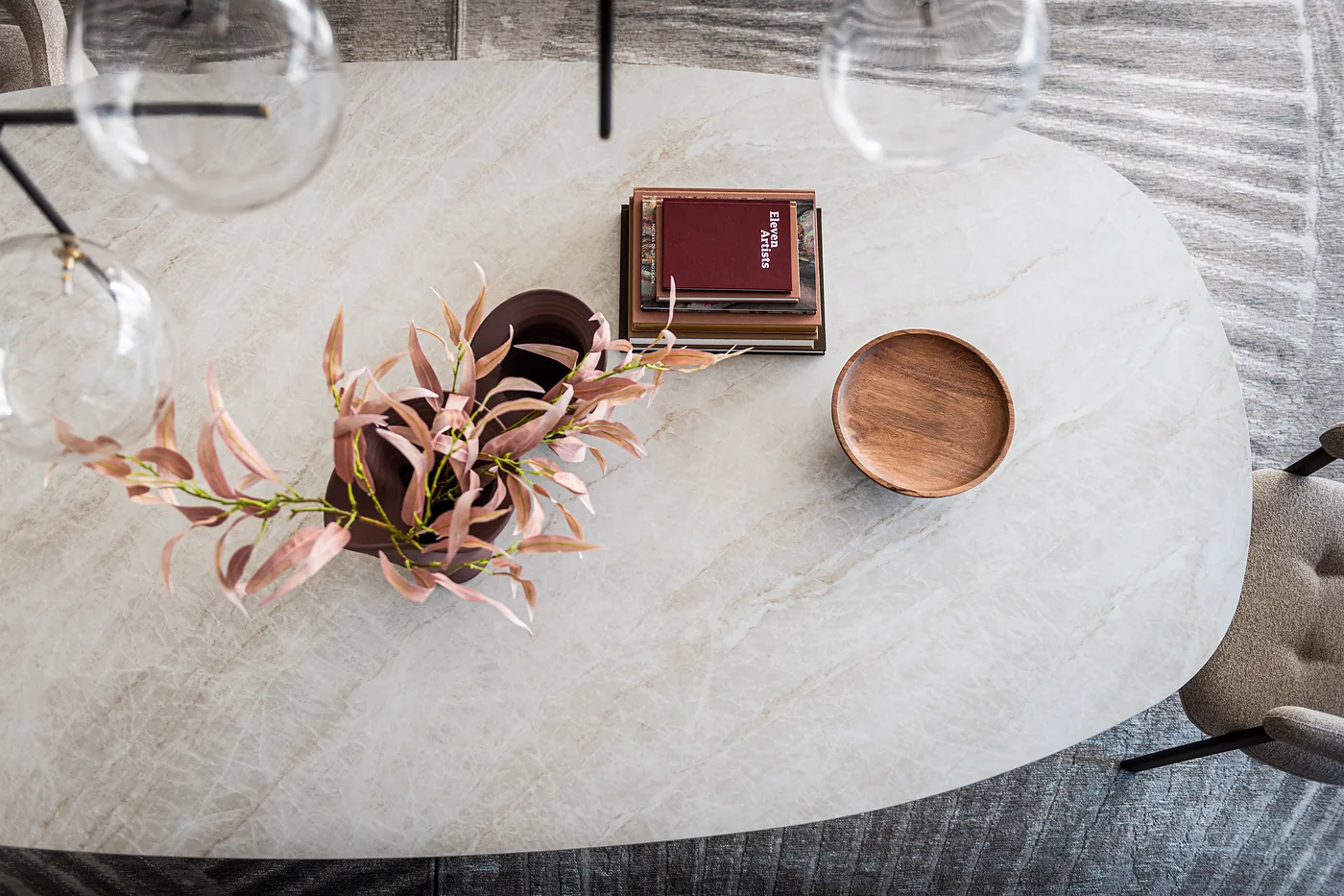 Plateau en céramique claire vu de dessus, avec un bouquet et une coupe en bois