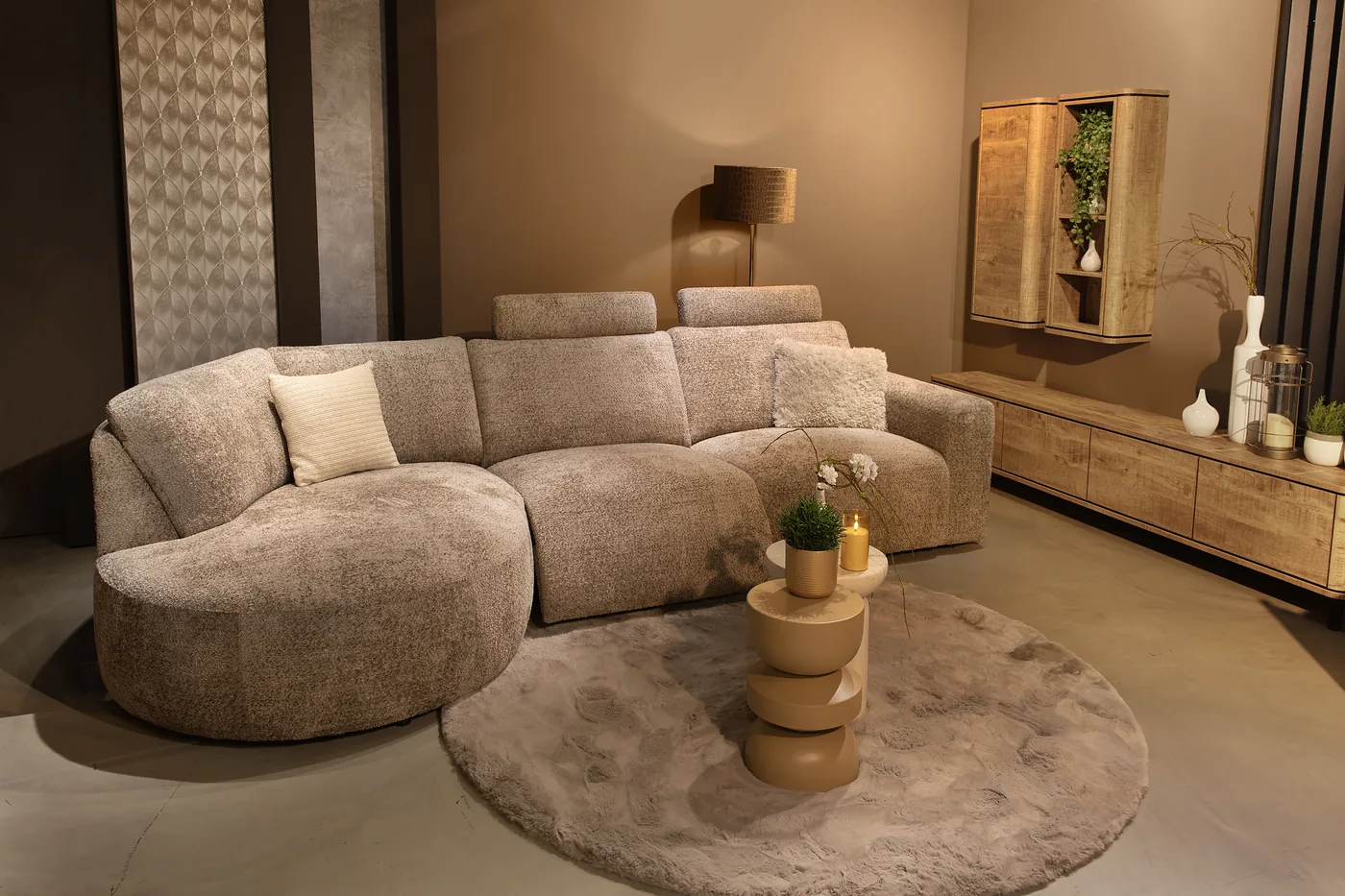 Salon aux formes arrondies en tissu texturé beige, dans un séjour aux tons chauds