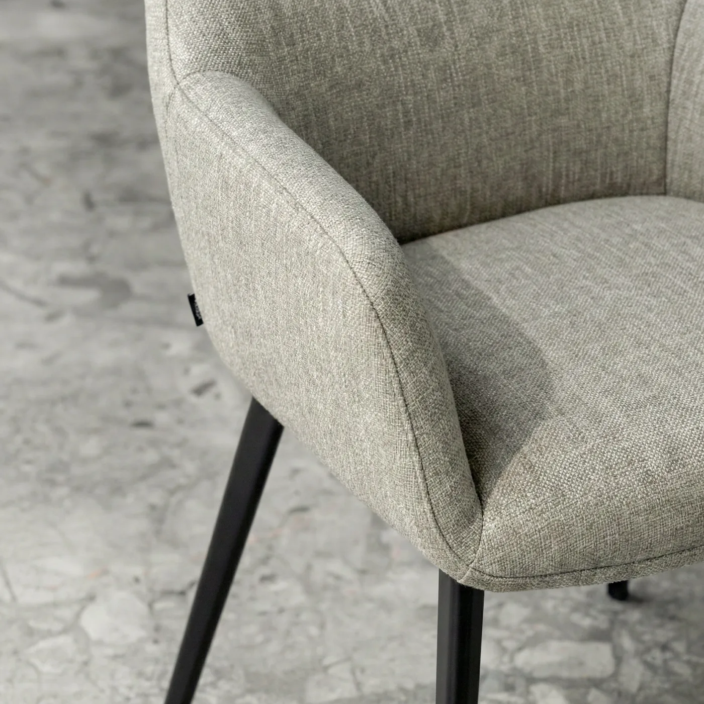 Chaise en tissu chiné gris vert, accoudoir enveloppant, vue de près