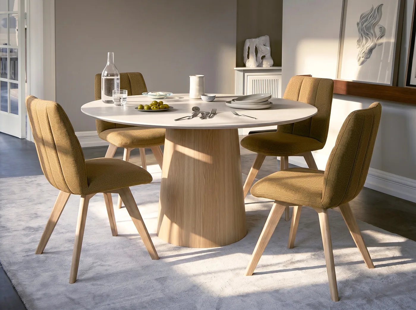 Chaises en tissu moutarde sur pieds en bois autour d’une table ronde au pied central en bois