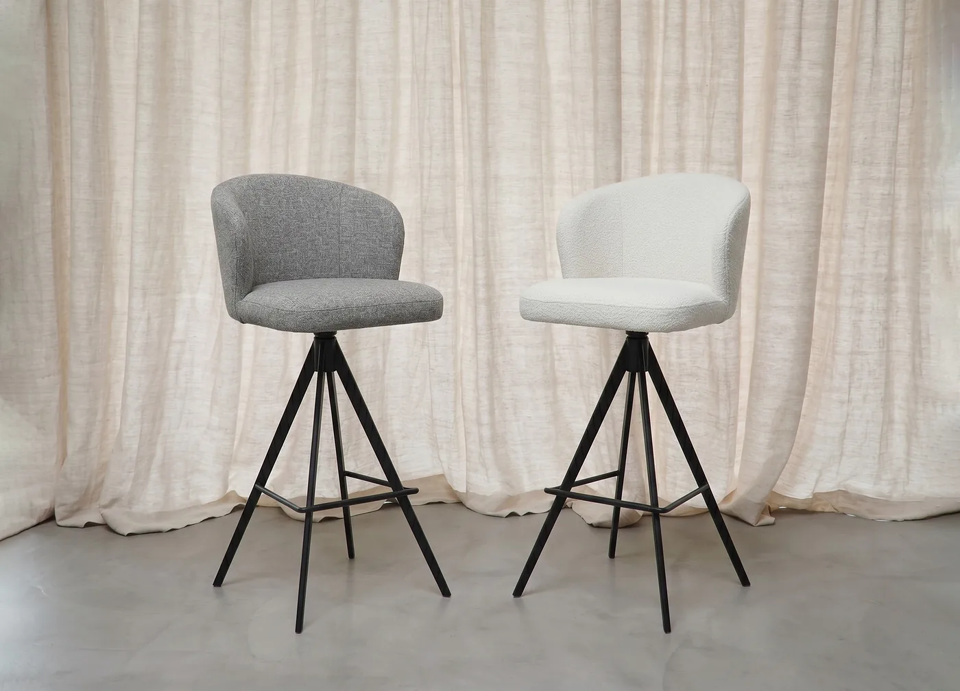 Deux tabourets de bar arrondis, tissu gris et tissu blanc, piétement noir