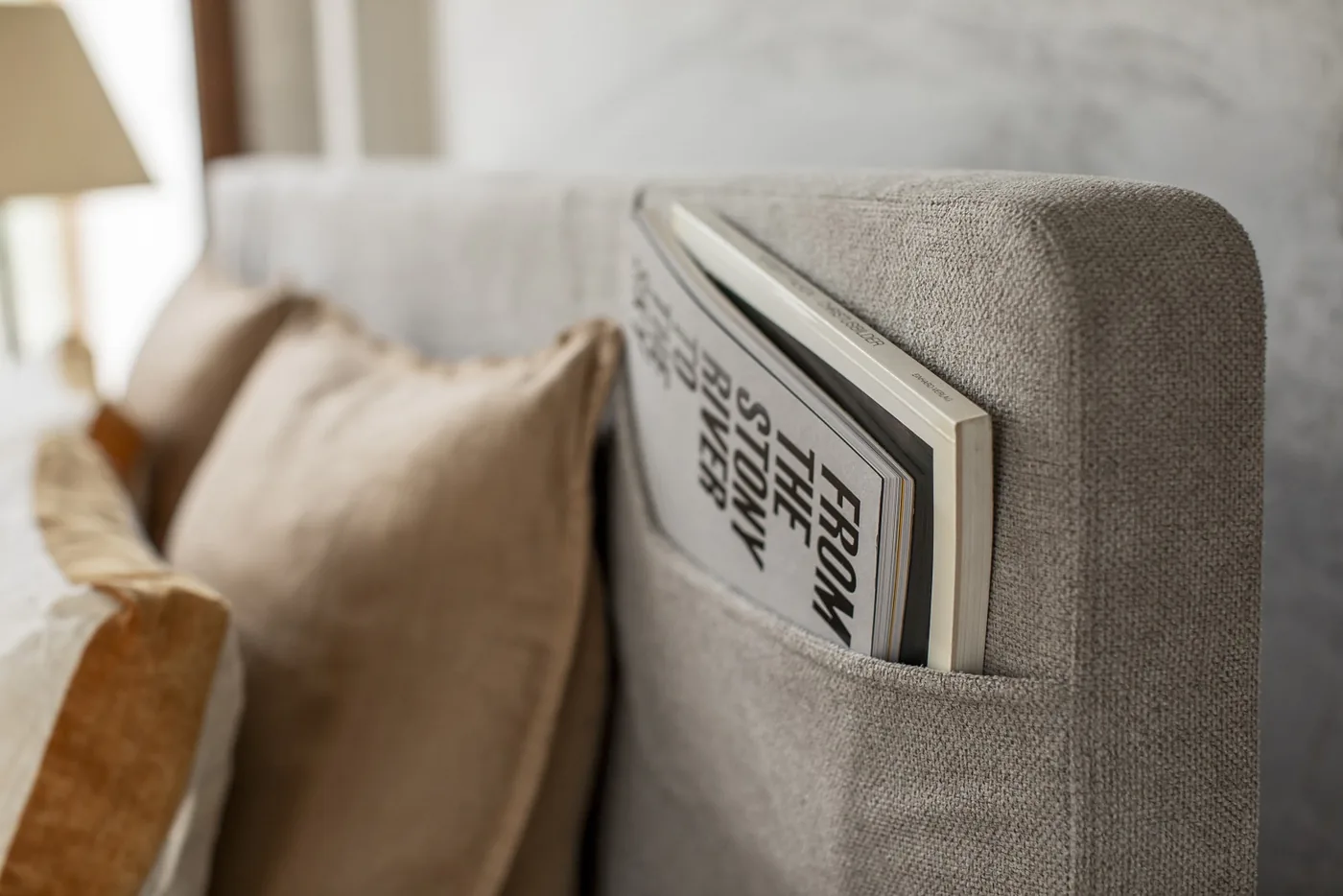 Tête de lit Fly en tissu, avec sa poche latérale où glisser un magazine